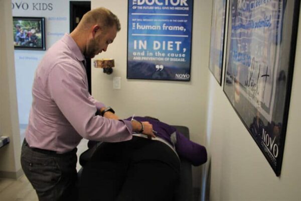 Dr.-Shane-Davidson-DC-doing-lower-back-adjustment-on-Patient